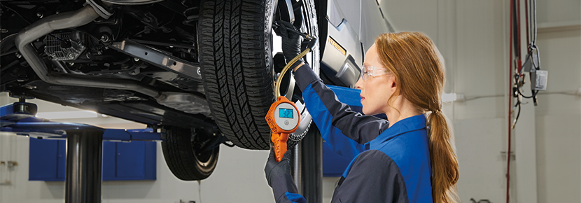 A Subaru technician checking tire pressure. | Sutherlin Subaru Huntington Beach in Huntington Beach CA
