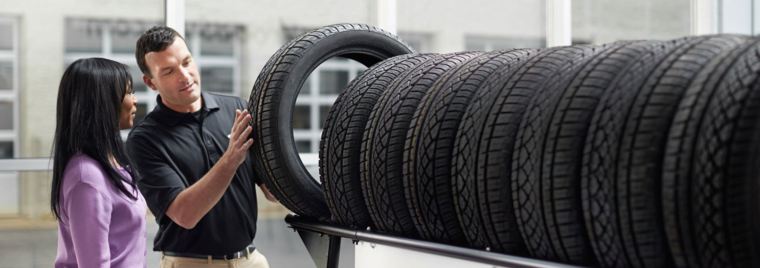 Subaru service representative showing customer a tire. | Sutherlin Subaru Huntington Beach in Huntington Beach CA